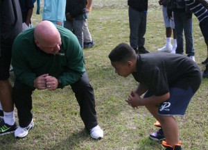 Football Head Coach Ian Shields works with a student at Arlington Heights Elementary School on Charter Day.