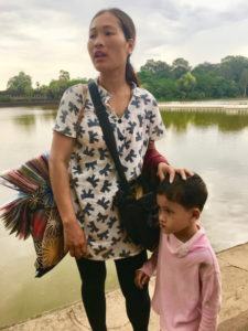 A mother and her son sell scarves to visitors at Angkor Wat
