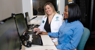 Article Feature Image of a Nurse working with a student at a computer