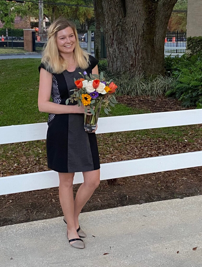 Photo of Katie Jackson Webber holding a bouquet of flowers outside the ceremony on award night