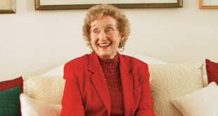 Dr. Frances Bartlett Kinne Smiling while sitting on a couch